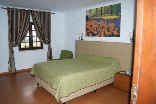 a bedroom with a bed and a painting on the wall at Hotel Rural A Coutada - Peniche in Atouguia da Baleia