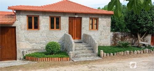 a small house with a staircase in front of it at Quinta da Urtigueira in Felgueiras