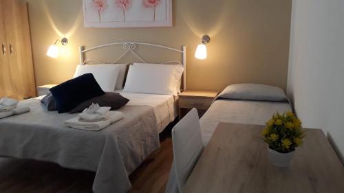 a bedroom with two beds with towels and a table at Giardino dei Baroni house in Marina di Mancaversa