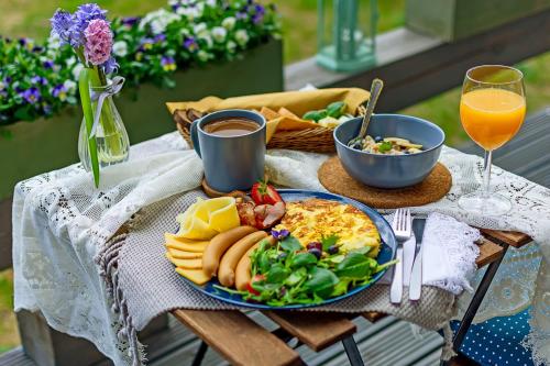 a breakfast table with a plate of food and drinks at Green Valley vacation homes in Žocenes Ciems