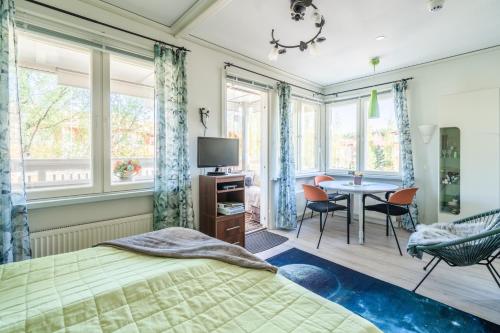 a bedroom with a bed and a table and chairs at Pinjakoti in Lahti