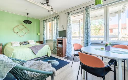 a bedroom with a bed and a table and chairs at Pinjakoti in Lahti