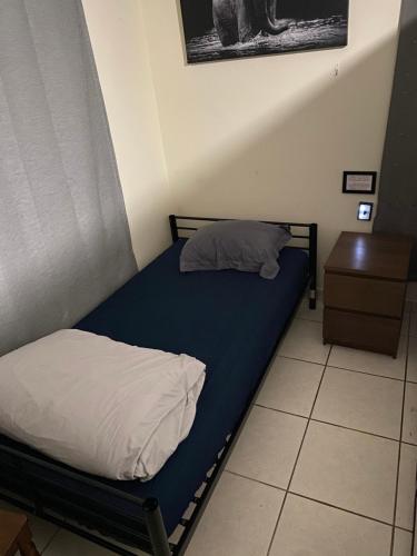 een slaapkamer met een bed met een blauwe matras en een tafel bij Private Cubicle - Single Bed - Mixed Shared Dorm - MIAMI AIRPORT in Miami