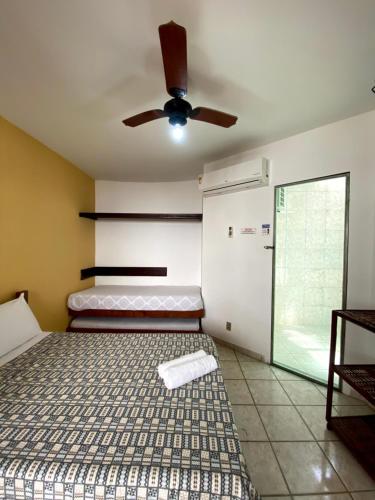 Schlafzimmer mit einem Bett und einem Deckenventilator in der Unterkunft POUSADA KANADY in Itacaré