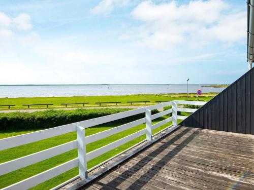 a boardwalk leading to the beach with a white fence at 8 person holiday home in Hemmet in Falen