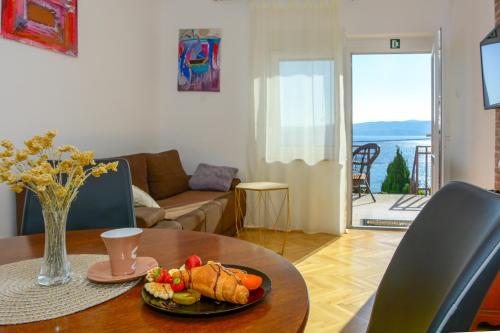 塞尼的住宿－Apartmani Krijesnica，客厅里设有一张桌子,上面有盘子的食物