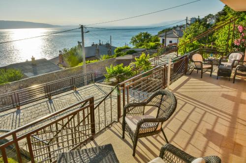 einen Balkon mit Stühlen und Blick auf das Wasser in der Unterkunft Apartmani Krijesnica in Senj