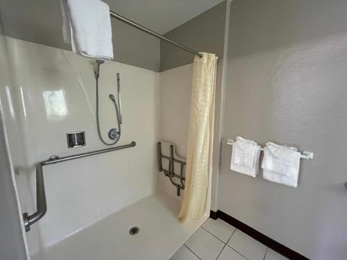 a bathroom with a tub and a shower with towels at Pinewood Inn in South Lake Tahoe