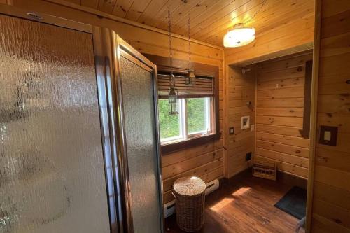 a bathroom with a shower in a wooden cabin at Joy's Chalet - Hottub, Lake, & Cottage in Val-des-Bois