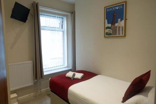 a small room with two beds and a window at The Kings Cross Hotel in Blackpool