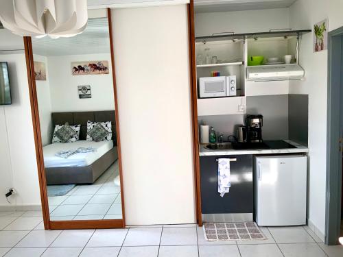 a mirror in a room with a kitchen and a bed at LE ROSA PARKS CLÉMARTHA in Kourou