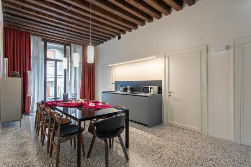 een eetkamer met een zwarte tafel en stoelen bij Palazzo Venere Apartments in Venetië