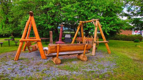 eine hölzerne Schaukel in einem Park in der Unterkunft Motel Au Vieux Frontenac in Thetford Mines