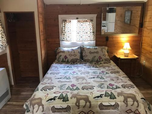 a bedroom with a bed with a blanket on it at Grandview Cabins & RV Resort in South Fork