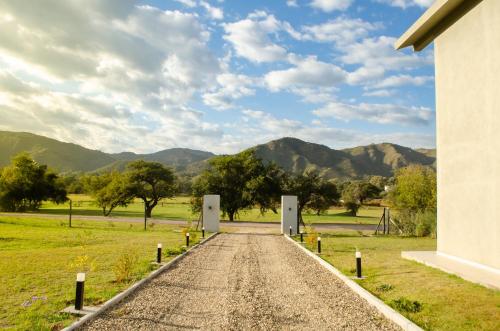 a dirt road leading into a field with mountains in the background at Los Cóndores Aparts. in Villa General Belgrano