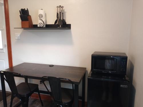 a small table with a microwave and a table with chairs at Yellowstone Riverside Cottages in Gardiner