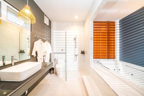 a bathroom with a tub and a sink and a shower at Resto Sea Resort - Baan Krut in Prachuap Khiri Khan