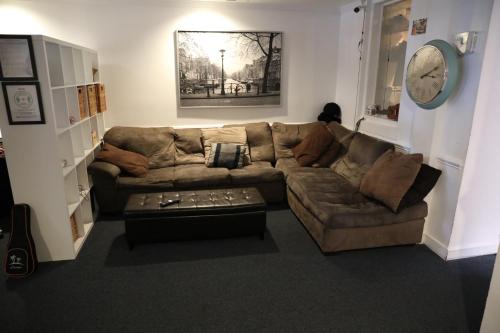 a living room with a couch and a clock on the wall at Duo Housing in Washington