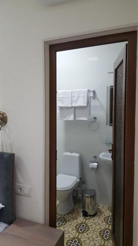 a bathroom with a white toilet and a sink at Registon Saroy Hotel in Samarkand