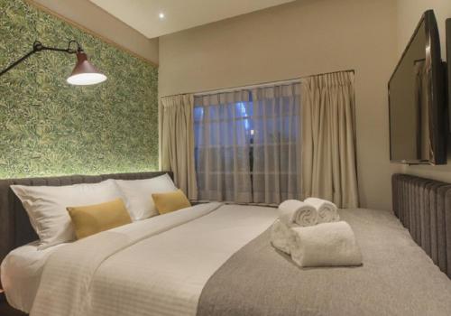 a bedroom with a large bed with towels on it at The Great Madras by Hotel Calmo in Singapore