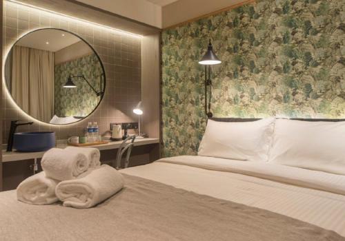 a hotel room with a bed with towels on it at The Great Madras by Hotel Calmo in Singapore