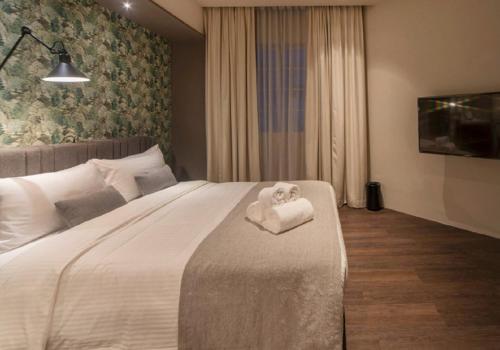 a bedroom with a bed with a towel animal on it at The Great Madras by Hotel Calmo in Singapore