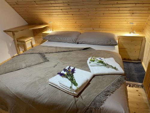 sypialnia z dwoma łóżkami z ręcznikami i kwiatami na nich w obiekcie Miha`s cottage w Bohinju