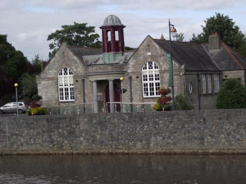 an old stone building with a clock tower on top at Twin Oaks Bed & Breakfast in Kilkenny
