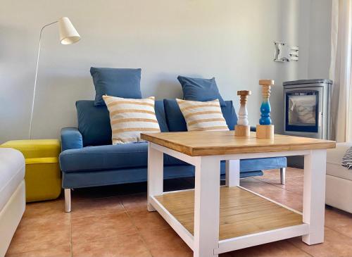 a living room with a blue couch and a table at Apartmenthaus Lütt Meer in Ludorf