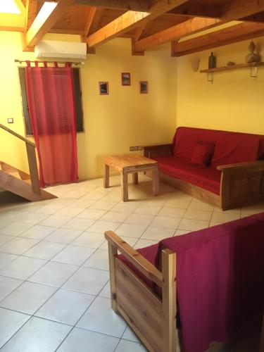 a living room with a red couch and a table at Pension Maria in Lefkada Town