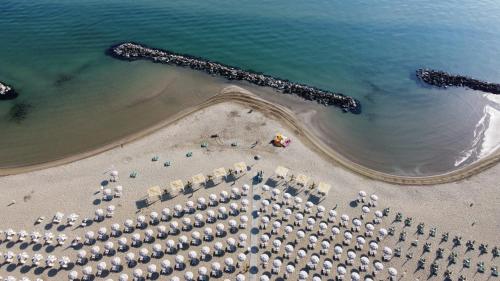 an overhead view of a beach with umbrellas and the ocean at Hotel Riva e Mare in Rimini