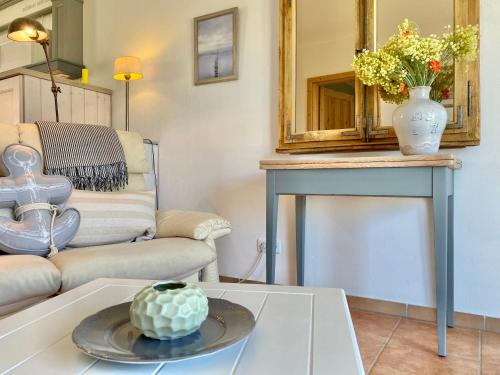 a living room with a couch and a table with a mirror at Apartmenthaus Lütt Meer in Ludorf