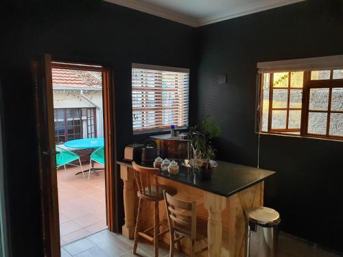 a kitchen with black walls and a counter and chairs at Melvilla Studio in Johannesburg