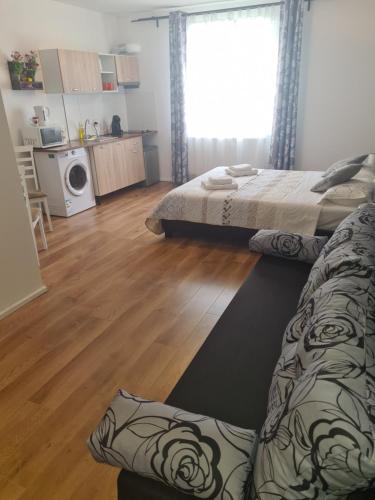 een woonkamer met 2 bedden en een houten vloer bij Luca's studio 2 ,Close to Therme Bucharest, Airport Otopeni in Baloteşti