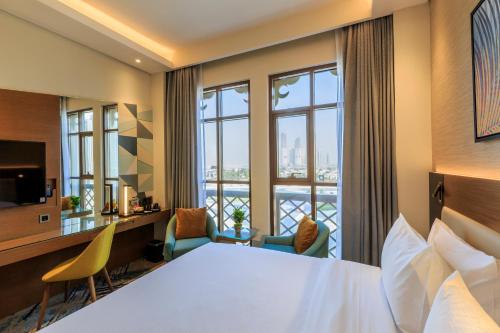 Habitación de hotel con cama y balcón en S19 Hotel-Al Jaddaf Metro Station en Dubái