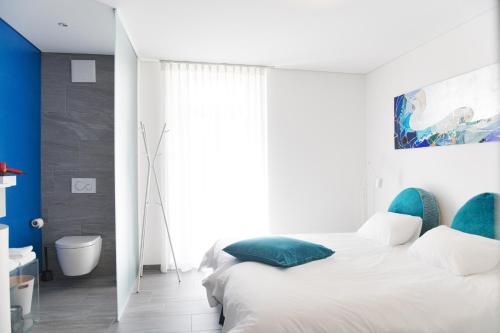a white bedroom with a bed and a bathroom at Salotto Brè - Bed & Breakfast charming rooms in Lugano