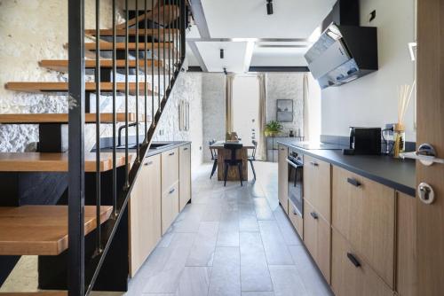 uma cozinha com armários de madeira e uma escada em espiral em SU MERI STAMPACE - Luxury apartment city center em Cagliari