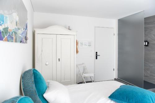 a bedroom with a white bed and blue chairs at Salotto Brè - Bed & Breakfast charming rooms in Lugano