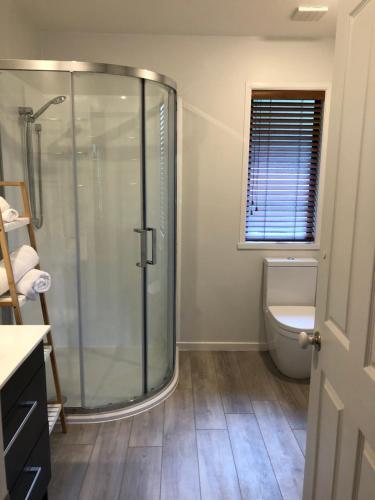 a bathroom with a shower and a toilet at Cherrywood Cottage in Akaroa