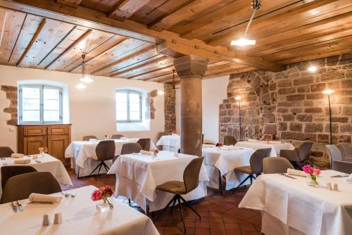 a restaurant with white tables and chairs and a brick wall at Kloster Hornbach in Hornbach