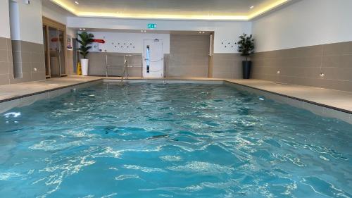a swimming pool in a building with blue water at Byron, Woolacombe 7 in Woolacombe