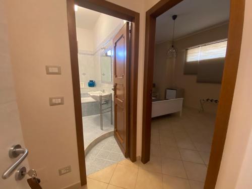 a bathroom with a door open to a bathroom with a sink at Le Camere di Rosanna in Marina di Gioiosa Ionica