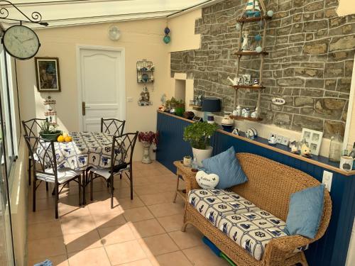 salon ze stołem i krzesłami oraz kamienną ścianą w obiekcie Les Voiles Vertes w mieście Moidrey