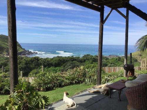 a view of the ocean from the porch of a house at CORAM DEO SaltyWaves double en-suite rooms with sea views in Coffee Bay