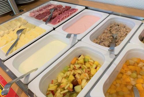 a table with trays of different types of food at Parkhotel Emmaus - Casa Rustico in Ascona