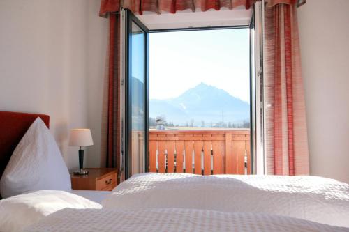a bedroom with a large window with a mountain view at Hotel Sonnenhof - bed & breakfast & appartements in Innsbruck