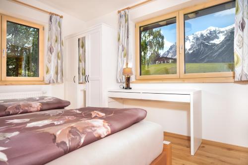 a bedroom with two beds and two windows at Appartement Sonnenheim in Ramsau am Dachstein