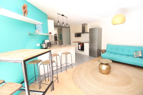 Il comprend une cuisine et un salon doté d'un canapé bleu. dans l'établissement Mon Appart A VILLON-MONPLAISIR, à Lyon