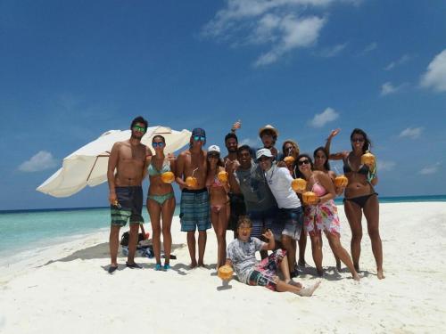 a group of people posing for a picture on a beach at Eden Blue in Thulusdhoo