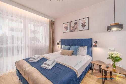 科沃布熱格的住宿－Apartament Kołobrzeski Relax，卧室配有蓝色和白色的床和一张桌子